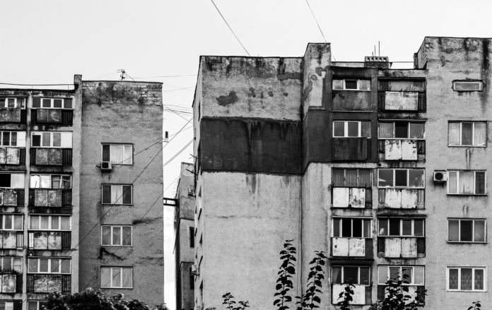 Czarno-białe zdjęcie zniszczonych bloków mieszkalnych w stylu PRL Czarno-białe zdjęcie zniszczonych bloków mieszkalnych w stylu PRL