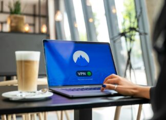 10 praktycznych zasad bezpieczeństwa danych w chmurze dla freelancerów i mikrofirm Osoba pracująca zdalnie w kawiarni na laptopie z włączonym VPN