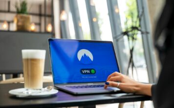 Osoba pracująca zdalnie w kawiarni na laptopie z włączonym VPN