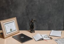 Jak legalnie używać stockowych zdjęć i ikon w projektach aplikacji i stron WWW Biurko prawnika z laptopem, dokumentami i statuą Temidy