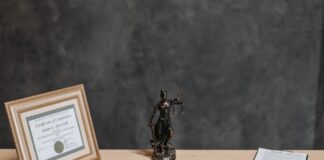 Biurko prawnika z laptopem, dokumentami i statuą Temidy