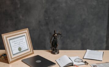 Biurko prawnika z laptopem, dokumentami i statuą Temidy