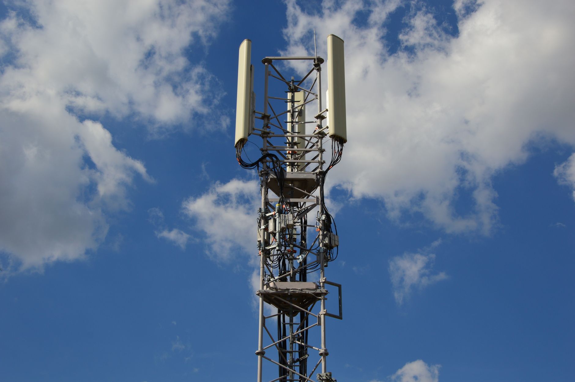 Maszt sieci komórkowej 5G na tle jasnoniebieskiego nieba