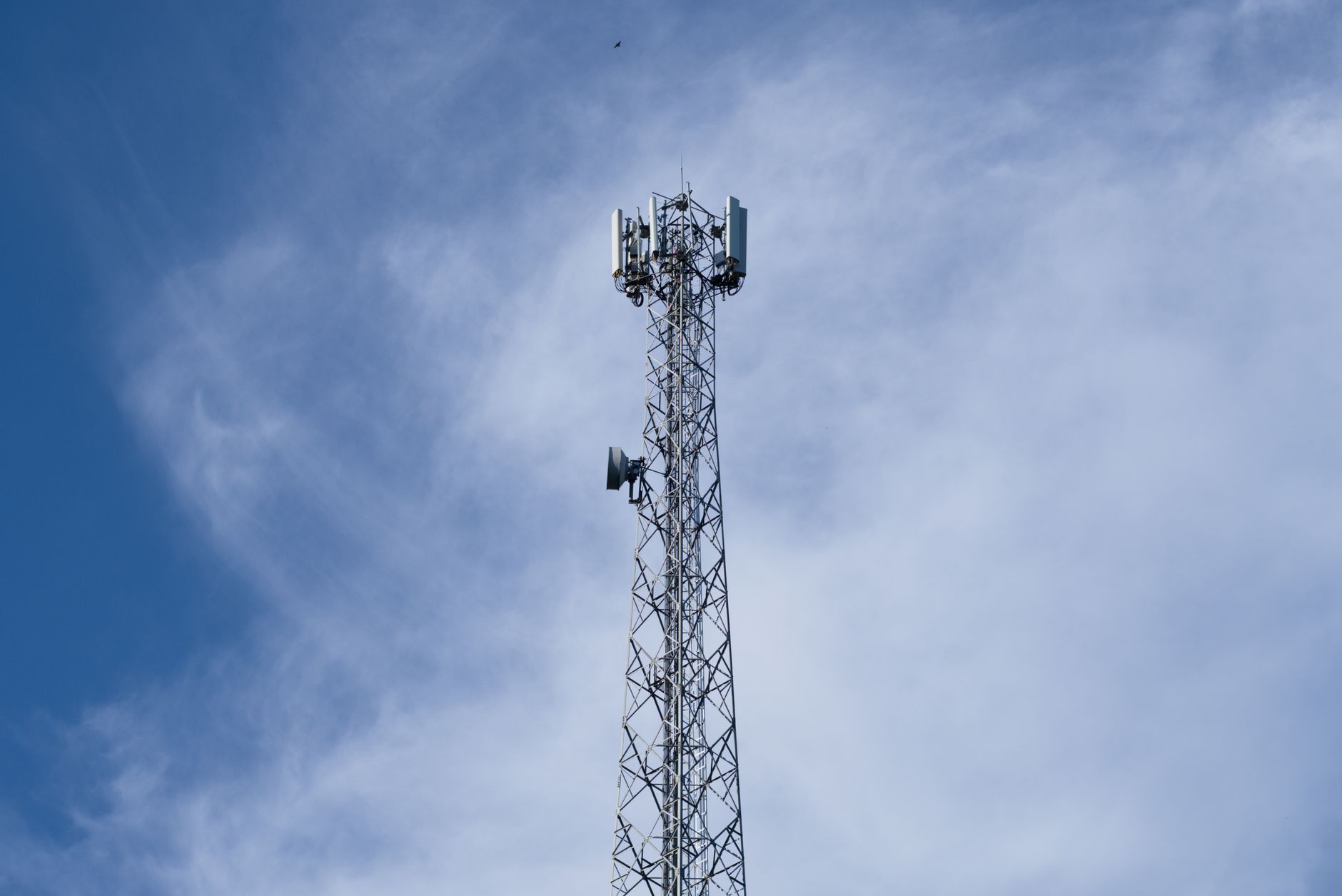 Maszt telekomunikacyjny 5G na tle nieba z chmurami