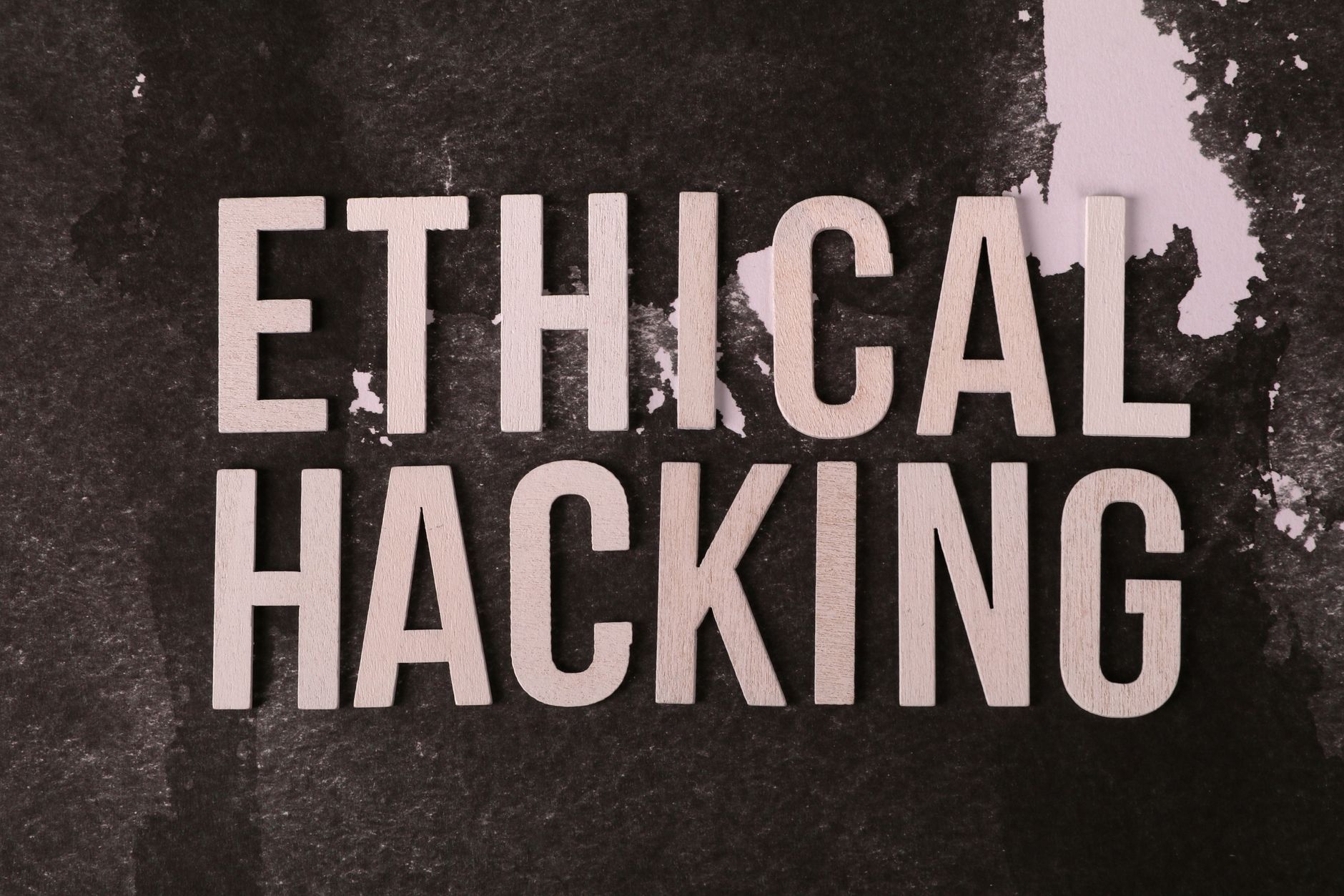 Napis Ethical Hacking na fakturowanym tle, motyw cyberbezpieczeństwa
