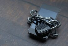 Utrata telefonu bez paniki: szyfrowanie, blokada zdalna i kopie zapasowe w świecie mobilnym Smartfon owinięty łańcuchem z kłódką symbolizującą silne zabezpieczenia