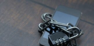 Smartfon owinięty łańcuchem z kłódką symbolizującą silne zabezpieczenia